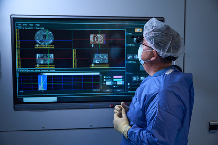 Surgeon reviewing patient data on OR monitorの写真素材