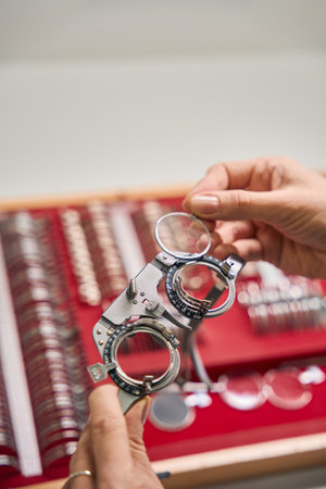 Hand holding a trial frame for lens testingの写真素材