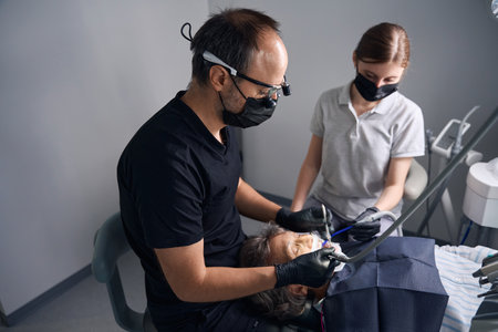 Dentist prosthetist works in binocular dental glassesの写真素材