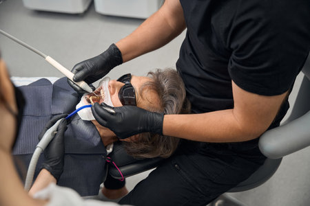 Patient is getting her teeth treated in a dental clinicの写真素材