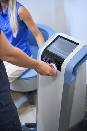 Close-up of a specialists hand adjusting medical equipmentの写真素材