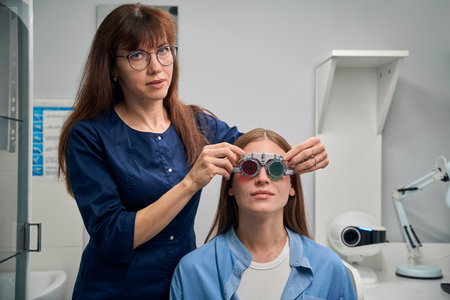 Patient wearing trial frame with optometrist assistance