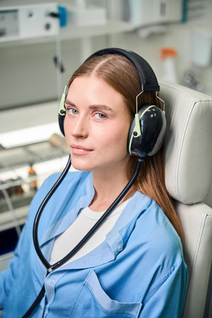 Female patient wearing headphones during an examinationの写真素材