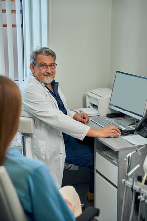 Adult doctor using computer during patient consultationの写真素材
