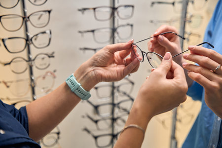 Close-up of caucasian hands holding eyeglassesの写真素材