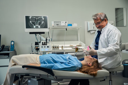Doctor conducting procedure on patient lying on tableの写真素材