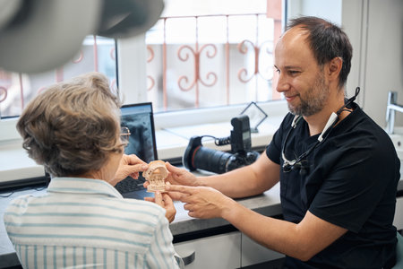 Dental prosthetist is consulting an elderly ladyの写真素材