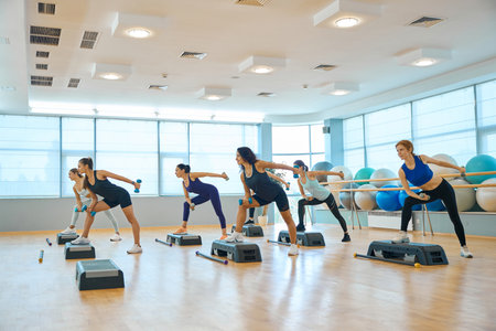 Group of women perform strength exercises with dumbbellsの写真素材