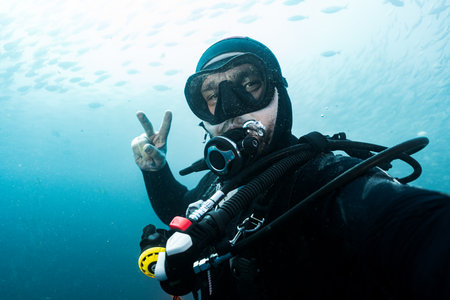 Scuba diver showing victory gesture underwater in the Mediterranean sea