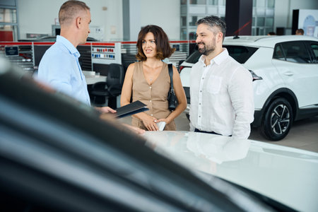 Car sales consultation taking place in dealership showroom