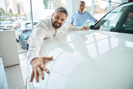 A person examining a vehicle in a car showroomの写真素材