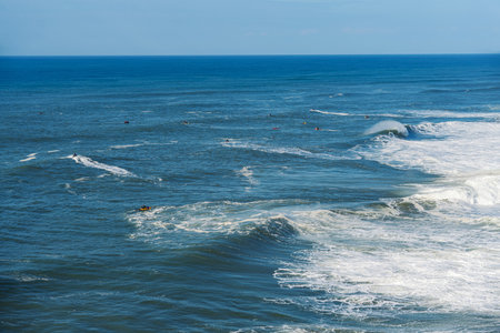 People surfing on surfboard in the ocean. Nazare, Portugalの写真素材