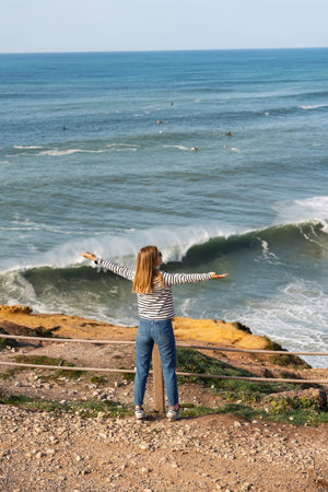 Woman tourist looking at panoramic view of ocean in Nazare, Portugalの写真素材