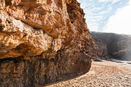Close up of beautiful rock and sandy beach in Nazare, Portugal