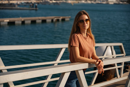 Beautiful of female traveler in sunglasses standing at port, looking at camera, Spainの写真素材