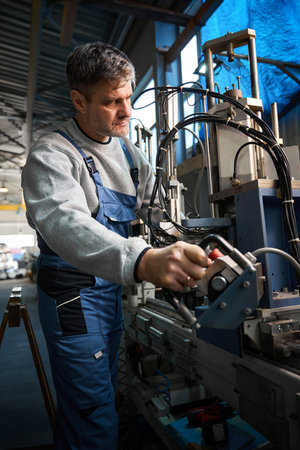 Man worker assembling PVC windows using advanced machinery at plant