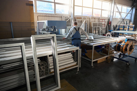 Repairman working in industrial workshop for PVC windows manufacturing