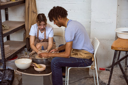 Young man and woman collaborating on pottery in studio