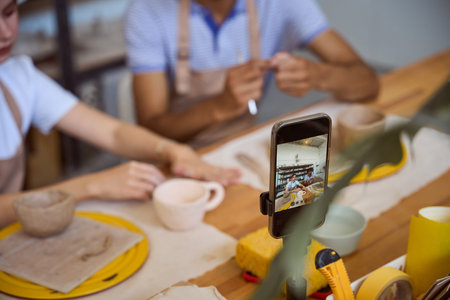 Focused woman and engaged man creating pottery in studio