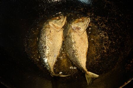 Overhead view, Fried couple mackerel fish in kitchen. Prepare food dinner. Fried via vegetable oil...