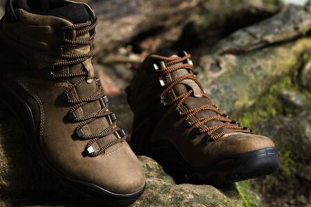 Brown leather hiking boot on wood.