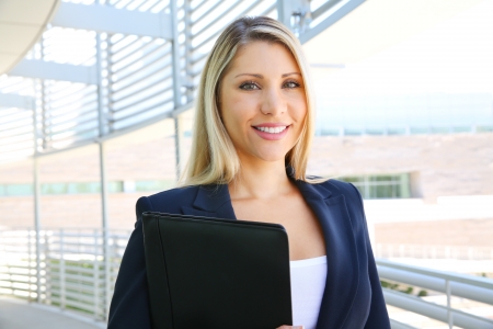 Business woman standing in business building with folderの写真素材