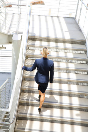 young businesswoman walking on stairsの写真素材