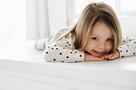 A young girl sitting on a bed. High quality photoの写真素材