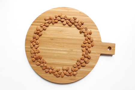 round frame of apricot pits on a wood kitchen boardの写真素材