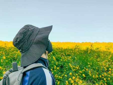 Young man asian traveler wearing mask enjoying at Mexican sunflower field on Tung Bua Tong, Mae Moh, Lampang, Thailand. Travel conceptの写真素材