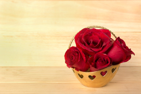 Red rose in gold basket, Valentines Day, wedding day, wood background.の写真素材