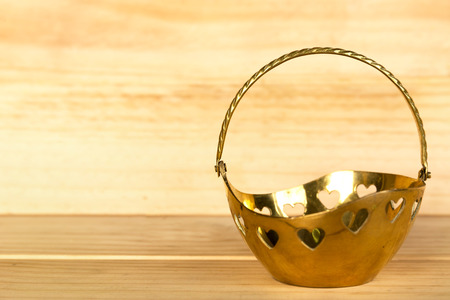 gold basket and wood background.の写真素材