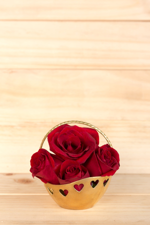 Red rose in gold basket, Valentines Day, wedding day, wood background.の写真素材