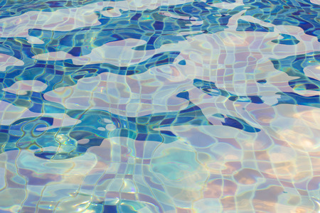 Blue pool water with sun reflections