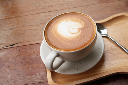 Latte Coffee art on the wooden deskの写真素材