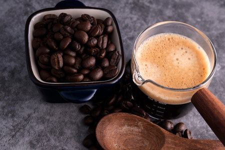 Hot coffee with roasted coffee beans on a cement floorの写真素材