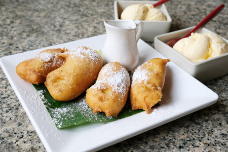 Fried bananas sprinkled with sugar and honeyの写真素材