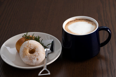 hot coffee with donuts on wooden tableの写真素材