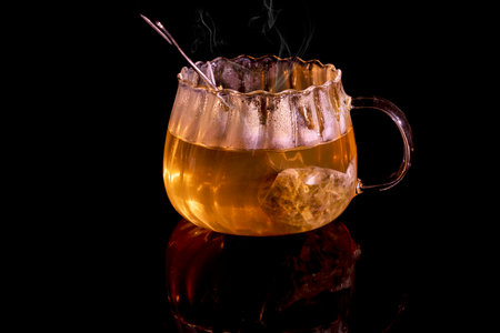 Hot tea on black background and reflectionの写真素材