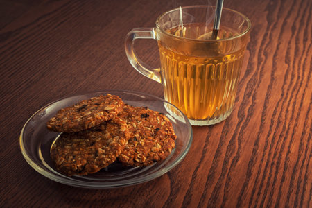 Hot tea and cookies on wooden tableの写真素材