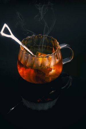 Hot tea on black background and reflectionの写真素材