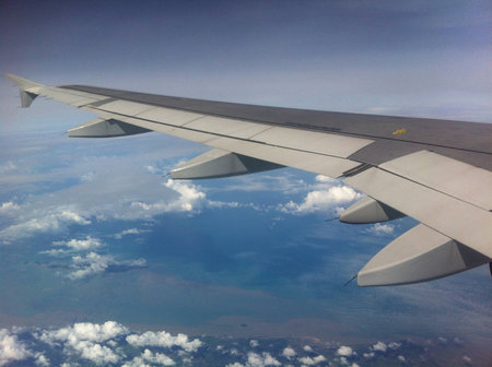 Wing of airplane fight above the clouds in the skyの素材