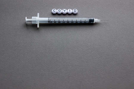 vaccine against covid-19, a syringe with a needle. Gray background. Space for textの写真素材