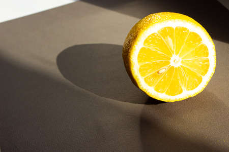 lemon lies on a gray background. Sunlight feeds on the lemonの写真素材