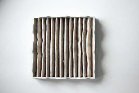 Clogged vacuum cleaner filter. Dusty filter White background.の写真素材