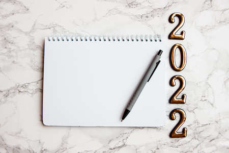 notebook with a blank sheet, a pen for writing plans for 2022
