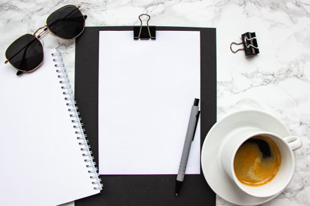 White cup with hot espresso coffee. Tablet, gray pen, sunglasses and blanket.の写真素材