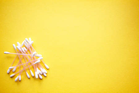 a lot of cotton buds on yellow background