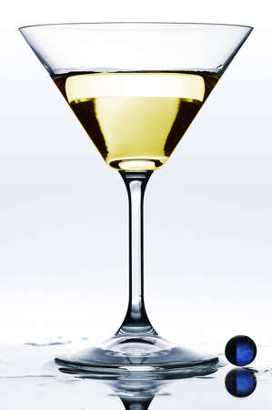 Glass with martini on wet mirrored tableの写真素材