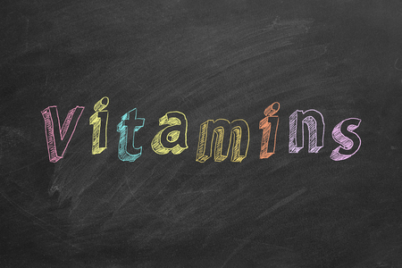 Hand drawing text Vitamins on blackboardの写真素材